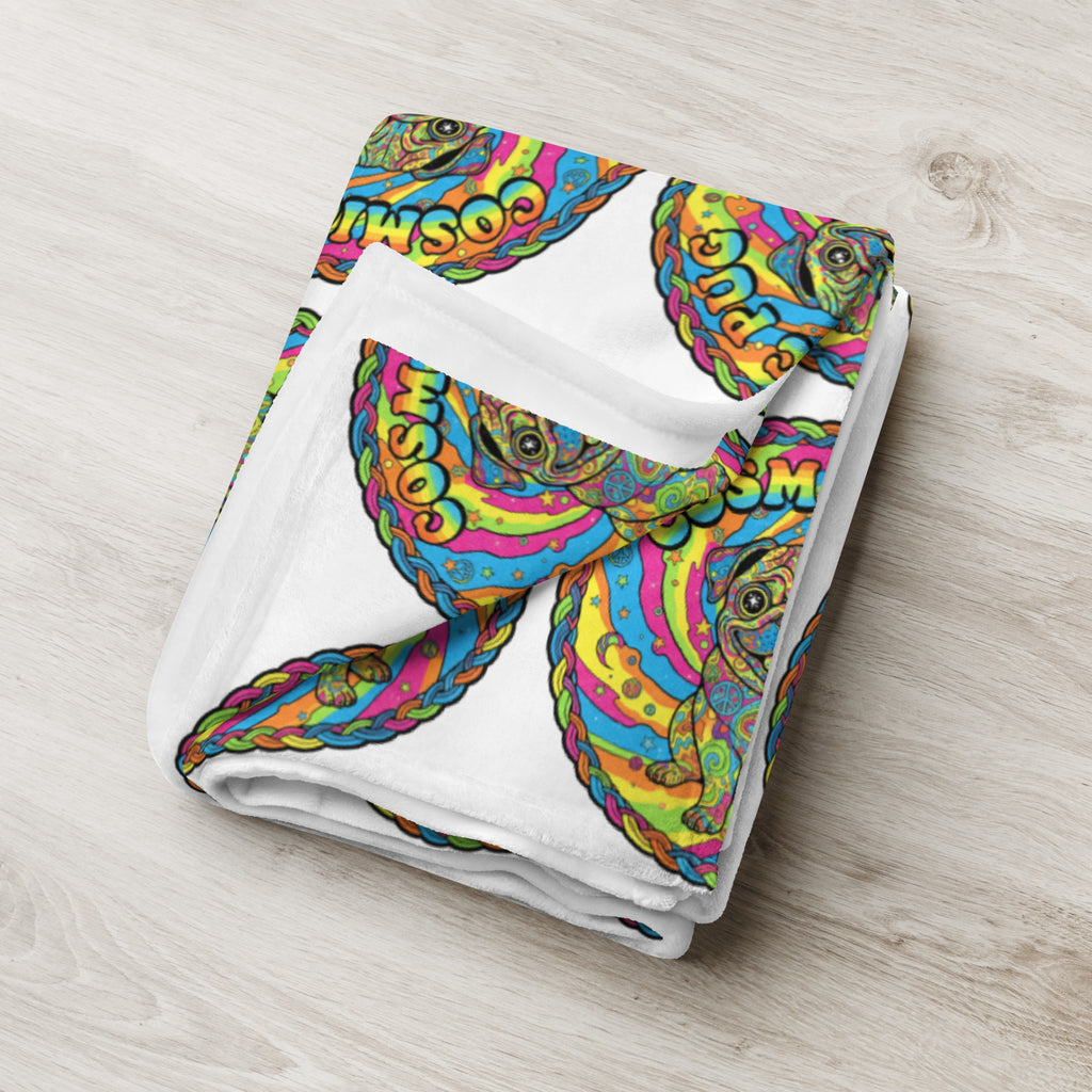 Leaky Ts Cosmic Pug throw blanket with cosmic pug pattern, soft fabric, 50x60 inches, shown draped on a sofa in a cozy living room setting.