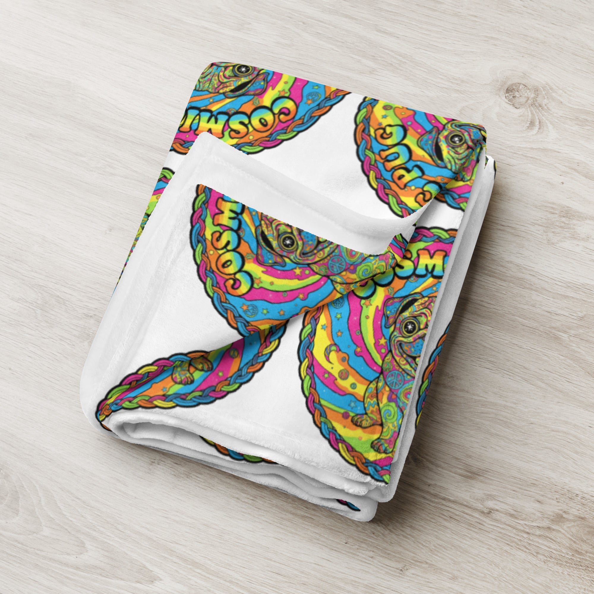 Leaky Ts Cosmic Pug throw blanket with cosmic pug pattern, soft fabric, 50x60 inches, shown draped on a sofa in a cozy living room setting.