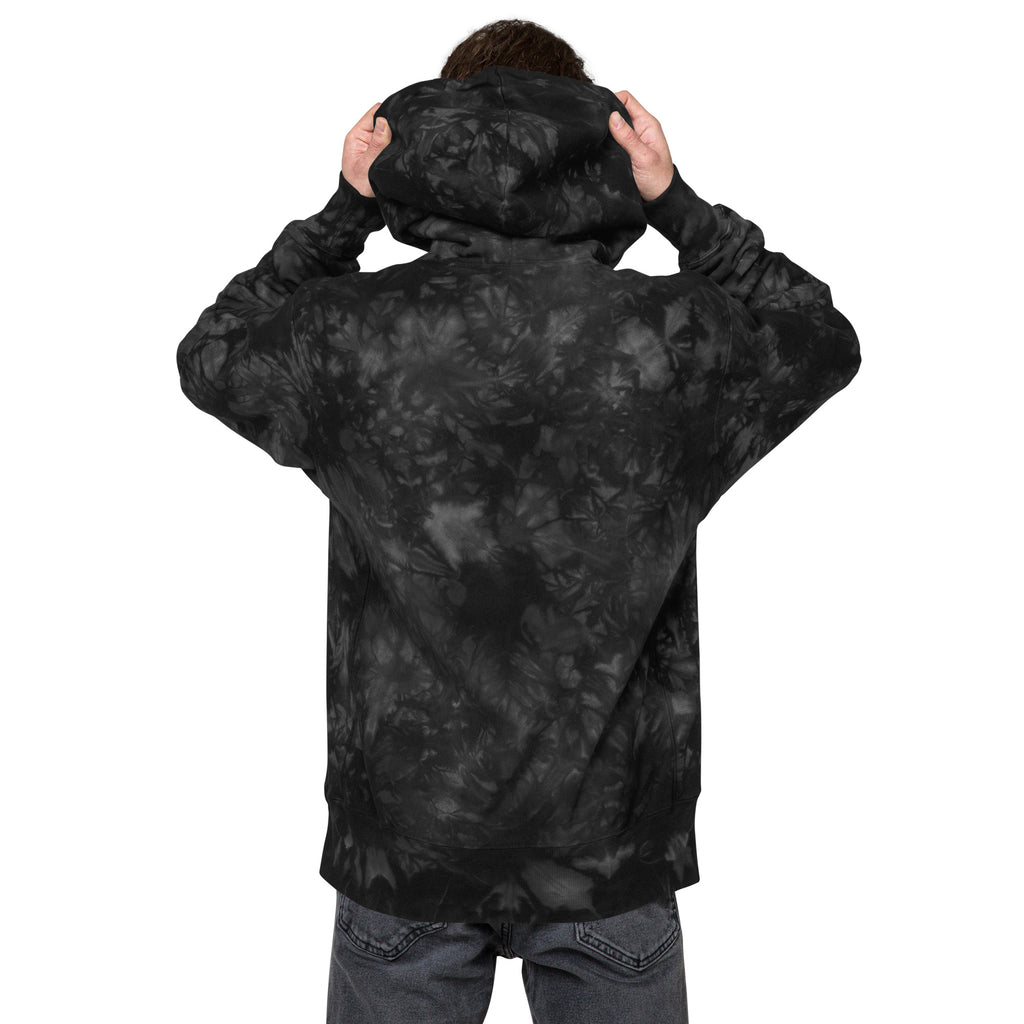 Unisex Champion Leak-Dye Hoodie in black with unique tie-dye pattern, featuring a relaxed fit and casual style.