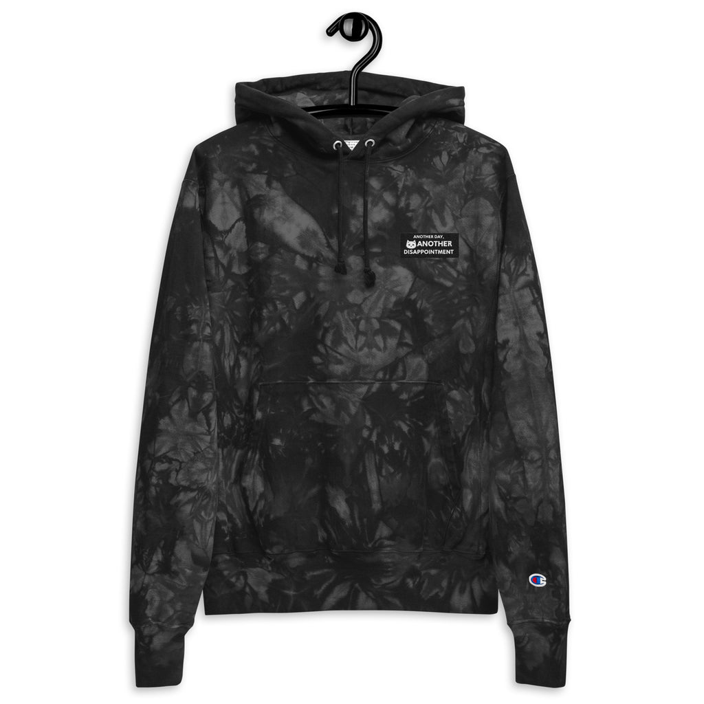 Unisex Champion Leak-Dye Hoodie from Leaky ts in black with bold tie-dye pattern, front view showing casual, relaxed fit.