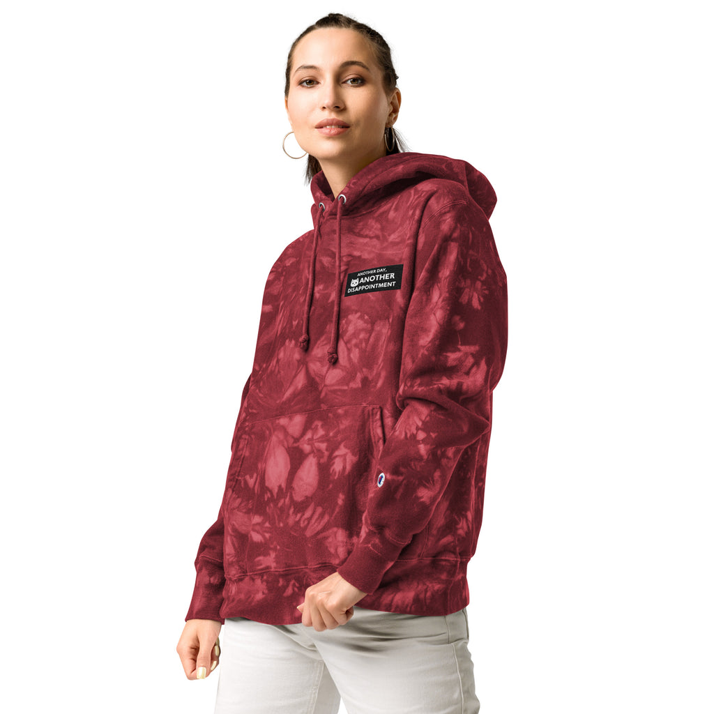 Leaky ts Champion Leak-Dye Hoodie in mulled berry color, unisex fit, front view showing vibrant tie-dye pattern and hood.